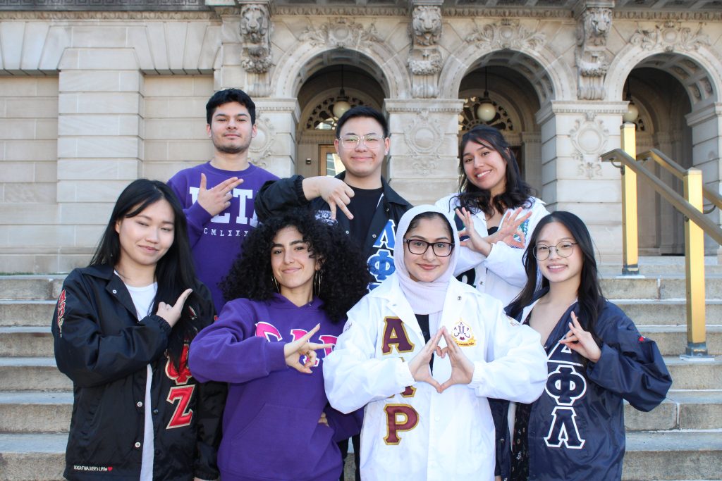 Group photo of different chapter members making hand signs.